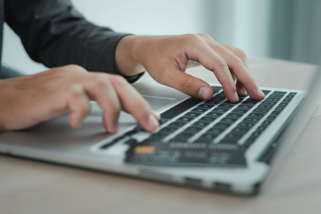 Person typing on laptop keyboard