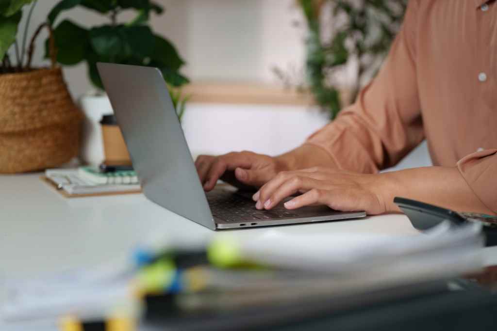 Close-up of hands of a business owner typing on a laptop